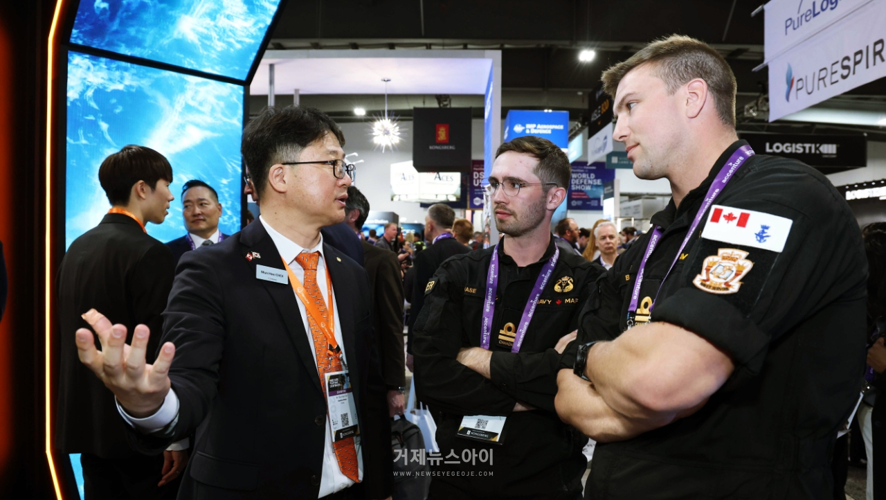 캐나다 오타와에서 열린 'CANSEC 2026' 전시회 내 한화오션 부스에서, 한화오션 관계자가 방문객들에게 최신예 잠수함인 KSS-III 모델을 소개하며 그 우수성을 설명하고 있다.