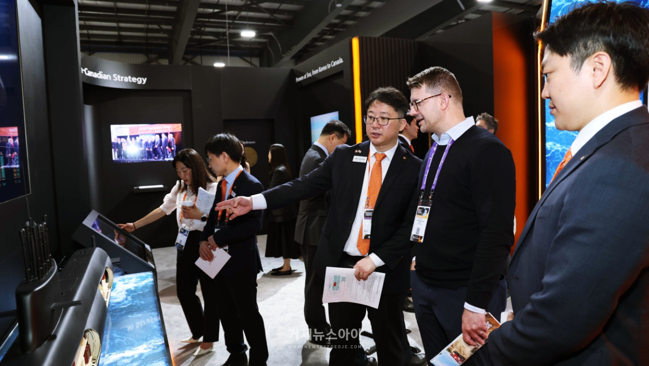 캐나다 오타와에서 열린 'CANSEC 2026' 전시회 내 한화오션 부스에서, 한화오션 관계자가 방문객들에게 최신예 잠수함인 KSS-III 모델을 소개하며 그 우수성을 설명하고 있다.