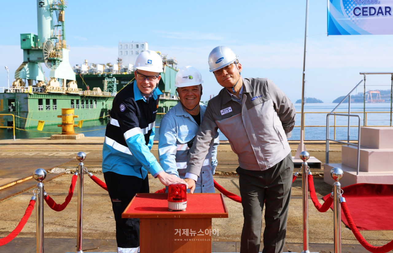 참석자들이 시더 FLNG 진수 시작을 알리는 버튼을 누르고 있다